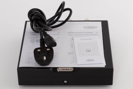 Top of a used Chord Electronics Bertti Power Amplifier in a Black finish showing Manual and Mains Cable