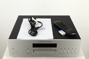 Top of a used Copland CDA823 CD Player in a silver finish showing Manual, Remote, 2x Batteries and Mains Cable