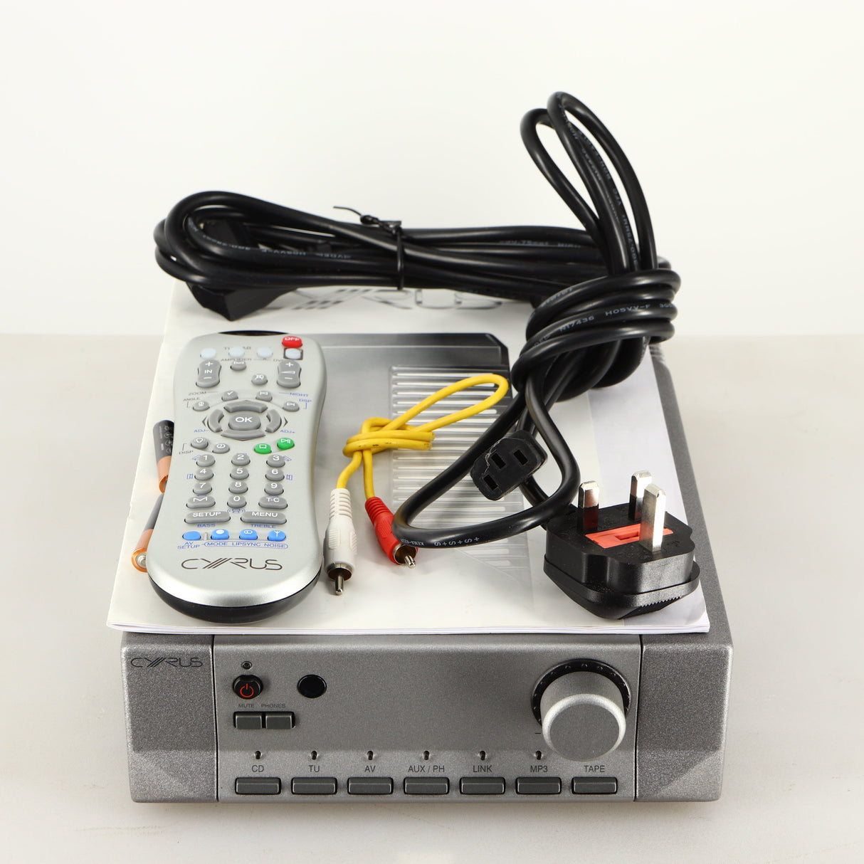 Top of a used Cyrus PRE VS2 Pre Amplifier in a quartz silver finish showing Manual, Remote, 2x Batteries, Interconnect Cable, Mains Cable and Schuko Cable