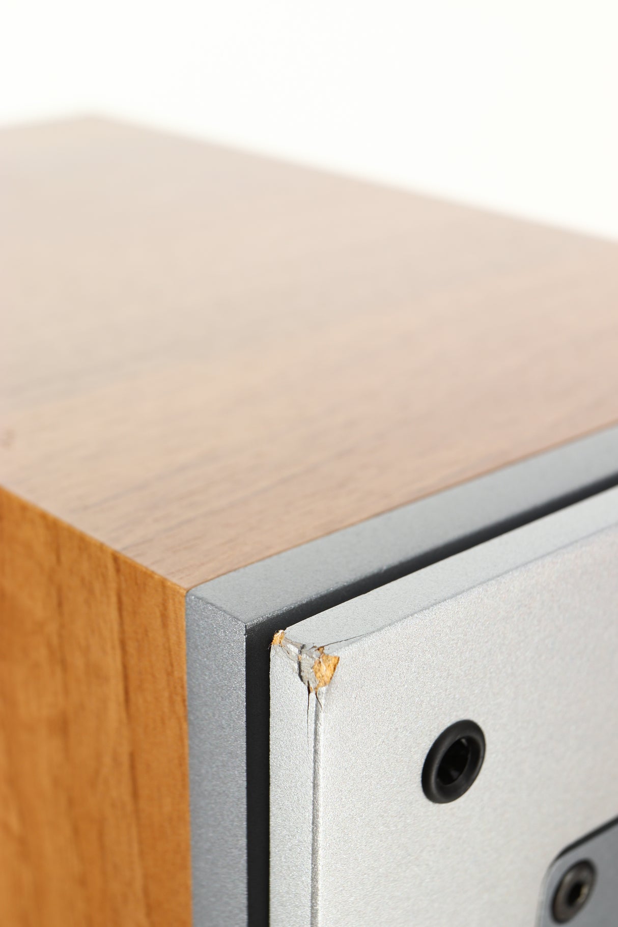 Close up of a used Dali Ikon 5 Floorstanding Speaker in an oak finish showing damage on front left corner