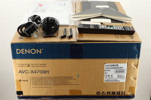 Box of a used Denon AVR-4700 AV Amplifier in Black finish showing mains cable, manual, remote, 2x antenna, setup mic and stand