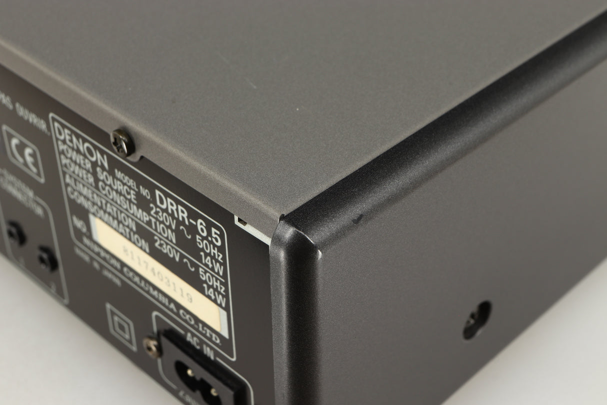 Close up of a used Denon DDR-6.5 Cassette Deck in a silver finish showing some scratches on rear left corner