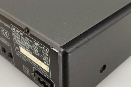 Close up of a used Denon DDR-6.5 Cassette Deck in a silver finish showing some scratches on rear left corner