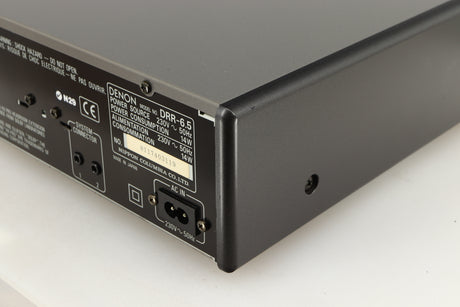 Rear left corner of a used Denon DDR-6.5 Cassette Deck in a silver finish