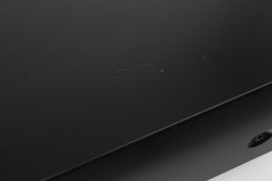 Close up view of a used Denon PMA-720 Integrated Amplifier in Black finish showing scratches on the top near the right side 