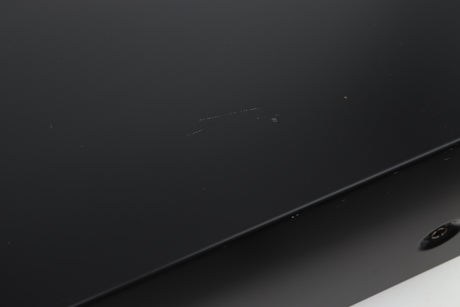 Close up view of a used Denon PMA-720 Integrated Amplifier in Black finish showing scratches on the top near the right side 