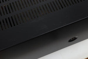 Close up view of a used Denon PMA-720 Integrated Amplifier in Black finish showing scratches on the top near the left side 