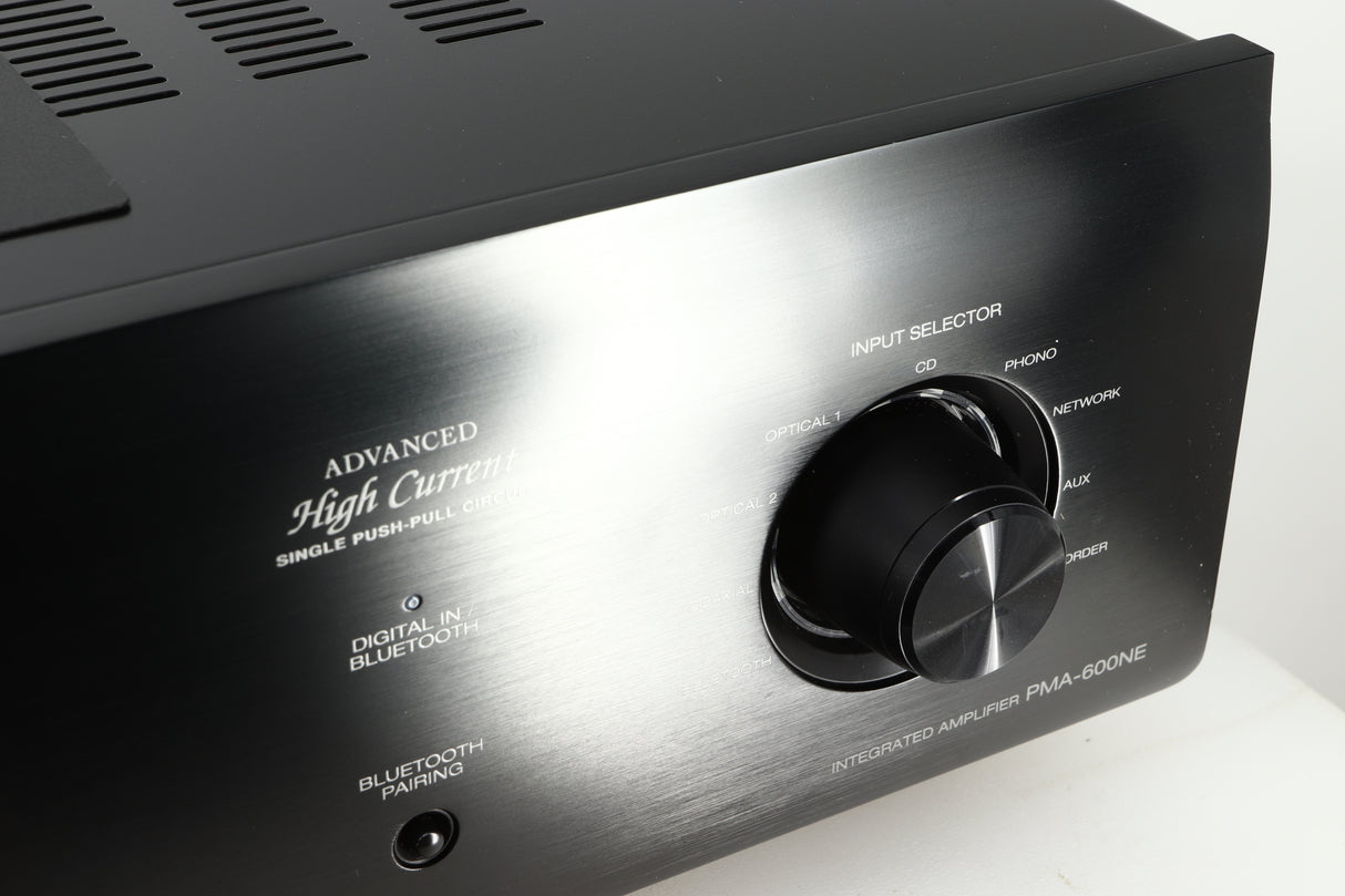 Close up of a used Denon PMA600 Integrated Amplifier in a black finish showing scratches on input selector knob