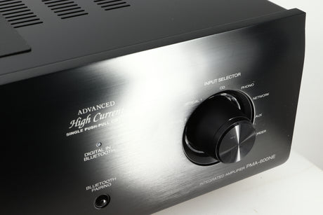 Close up of a used Denon PMA600 Integrated Amplifier in a black finish showing scratches on input selector knob