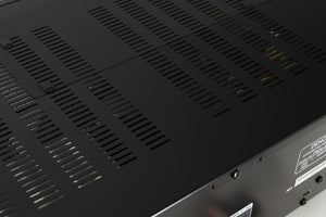 Close up of a used Denon PMA600 Integrated Amplifier in a black finish showing some light scratching on top