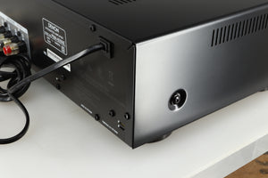 Rear left corner of a used Denon PMA600 Integrated Amplifier in a black finish