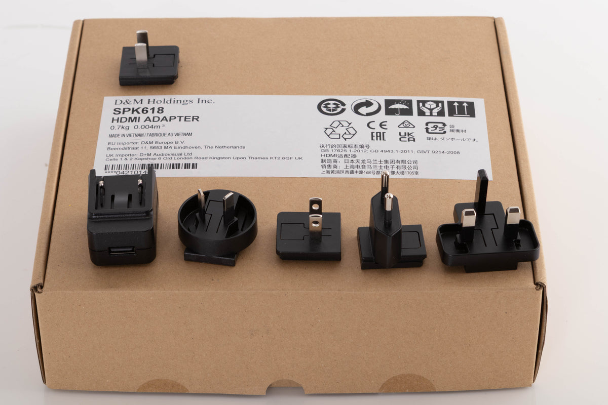 Box for a used Denon SPK618 HDMI Adaptor in a Black finish showing PSU, Mains Plug and Schuko Plug