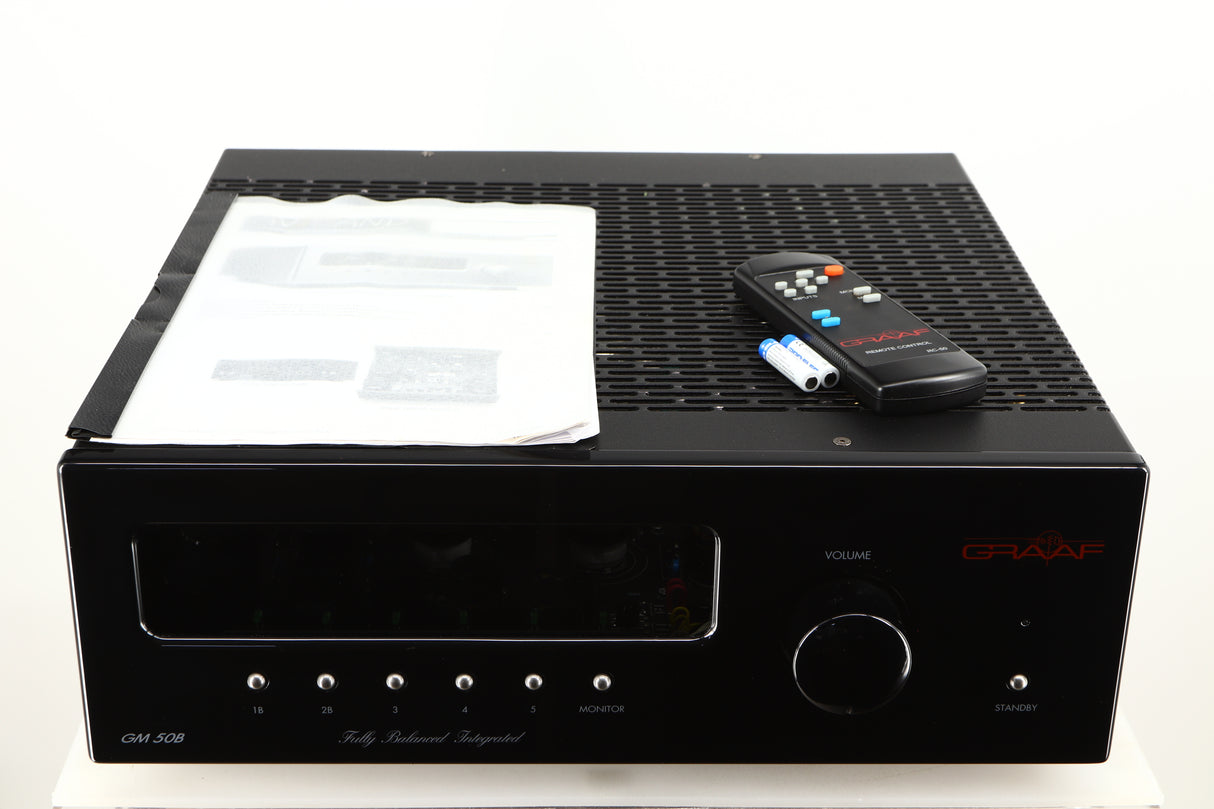 Top of a used Graaf GM50 Integrated Amplifier in a black finish showing Manual, Remote and 2x Batteries