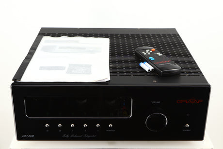 Top of a used Graaf GM50 Integrated Amplifier in a black finish showing Manual, Remote and 2x Batteries