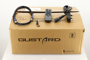 Box of a used Gustard R26 Discrete R2R DAC in Black finish showing mains cable, remote, USB cable, and Bluetooth antenna