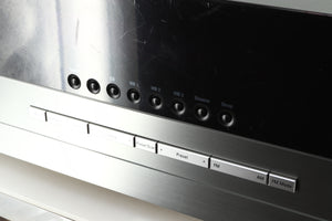 Close up of a used Harman Kardon 3380 Receiver in a silver finish showing scratching on the screen 