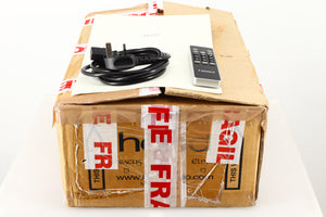 Box of a used Heed Abacus DAC in Black finish showing mains cable, manual, and remote 