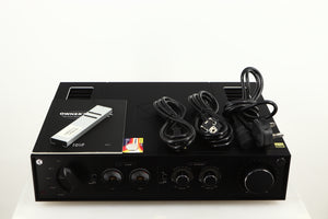 Top of a used HiFi ROSE RA280 Integrated Amplifier in a black finish showing Remote, Manual, Battery, Mains Cable and Schuko Cable
