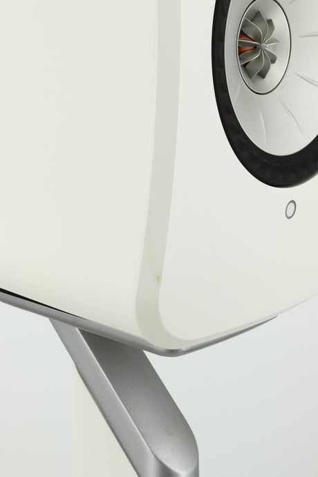 Close up of a used KEF LSX Standmount Speaker W/ Stand in a white finish showing a small mark on front left egde