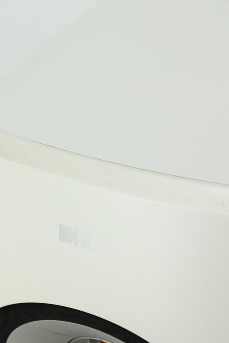Close up of a used KEF LSX Standmount Speaker W/ Stand in a white finish showing some wear on the front top edge
