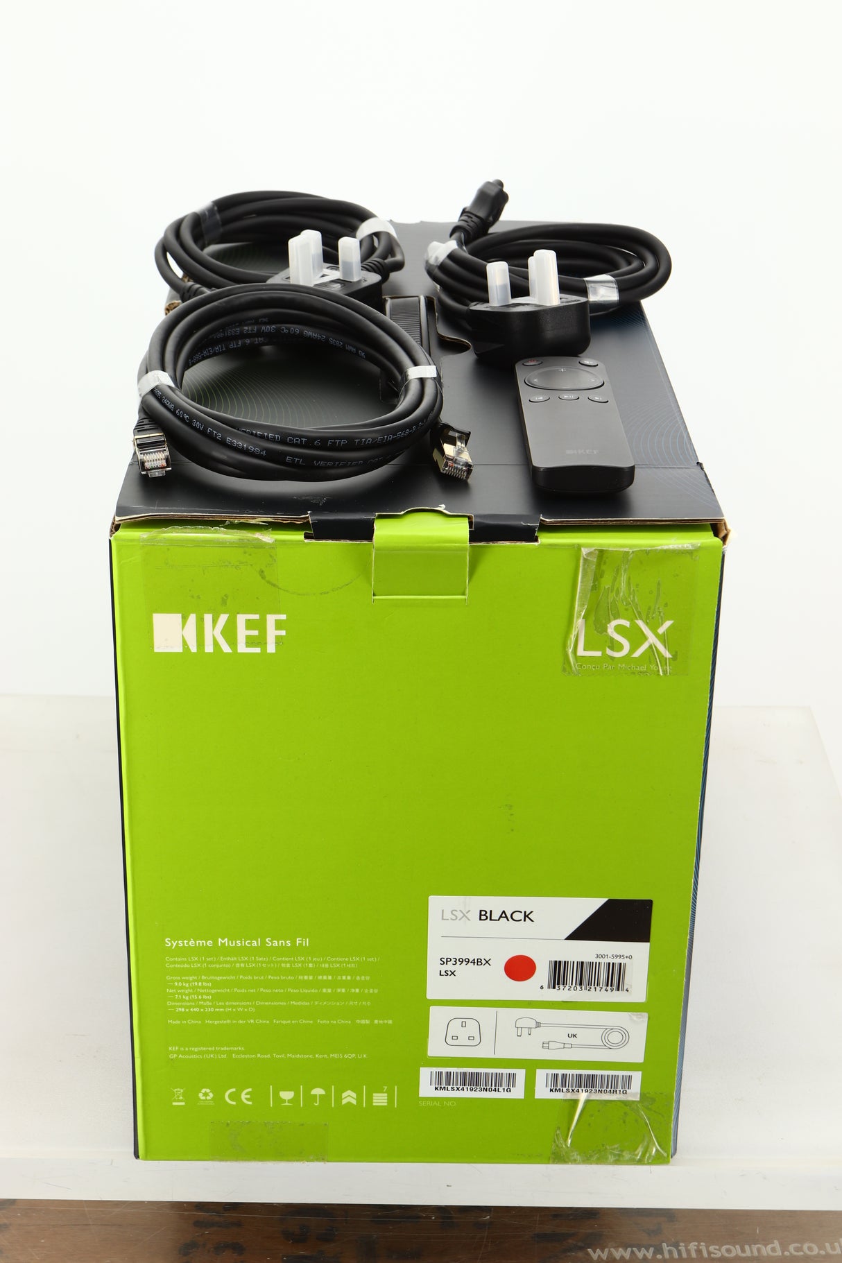 Box of a KEF LSX Wireless Standmount Speaker in Black finish showing mains cables, remote, and ethernet cable