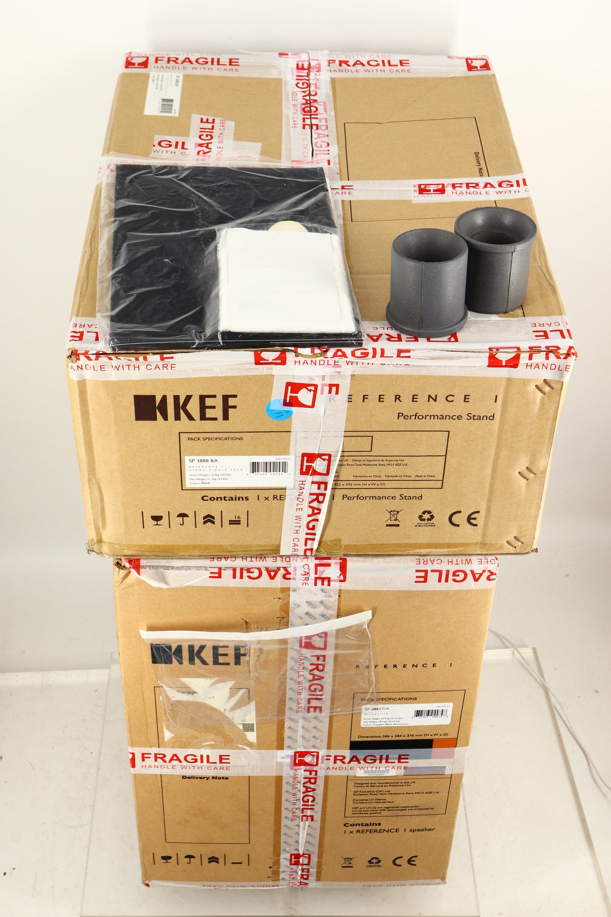 Boxes for a used KEF Reference 1 Standmount Speaker W/ Stand in a copper black aluminium finish showing Manual and Cleaning Cloth