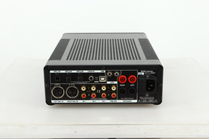 Rear view of a used Leema Acoustics Elements Integrated Amplifier in silver finish showing optical, balanced XLR, RCA, and mains inputs, and speaker outputs