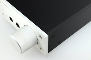 Close up of a used Lehmann Black Cube Linear Headphone Amplifier in a silver finish showing some marking on knob on fascia
