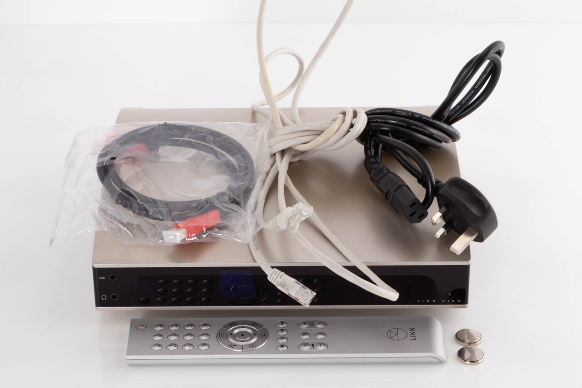 Top of a used Linn Kiko Digital Streaming System in a Champagne finish showing Mains Cable, Ethernet Cable, HDMI Cable, Remote and Batteries