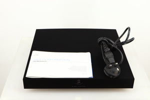 Top of a used Linn Klimax Exaktbox W/ Organic DAC in a black finish showing Mains Cable and Manual
