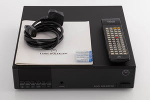 Top of a used Linn Kolektor Pre Amplifier in a Black finish showing Remote, Batteries, Manual and Mains Cable