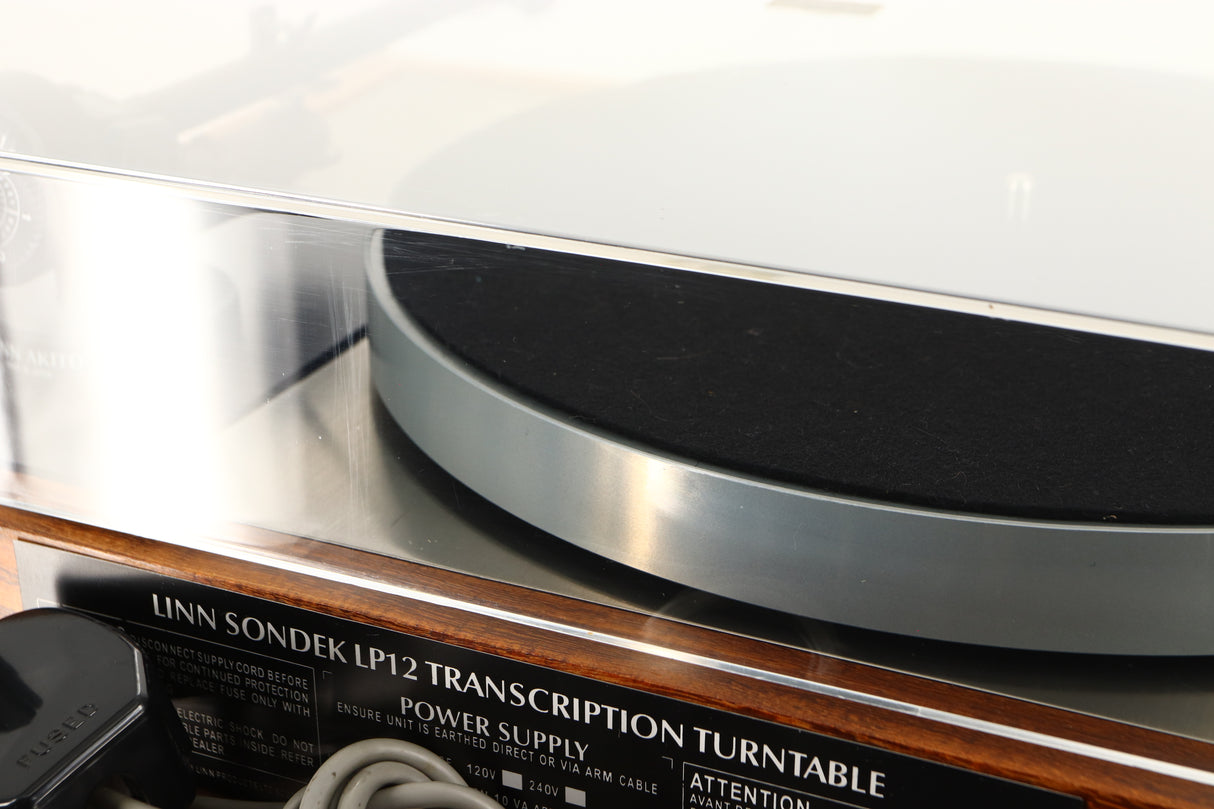 Close up of a used Linn LP12 Turntable / Akito Tonearm / Grado Prestige Blue Cartridge in an afromosia finish showing scratching on lid