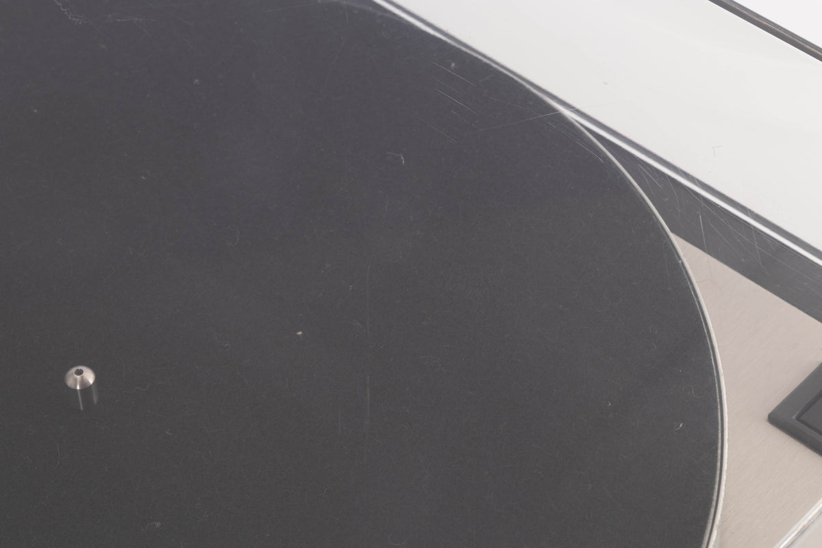 Close up of a used Linn LP12 Turntable / Basik Plus Tonearm / K-9 Cartridge in a Black Ash finish showing scratching on lid