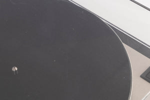 Close up of a used Linn LP12 Turntable / Basik Plus Tonearm / K-9 Cartridge in a Black Ash finish showing scratching on lid
