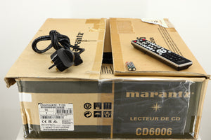 Box for a used Marantz CD6006 UK Edition CD Player in a silver finish showing Remote, Mains Cable and 2x Batteries