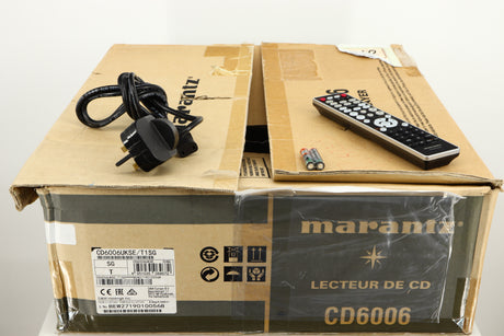 Box for a used Marantz CD6006 UK Edition CD Player in a silver finish showing Remote, Mains Cable and 2x Batteries