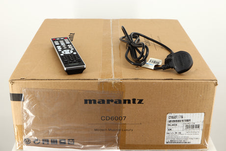 Box for a used Marantz CD6007 CD Player in a black finish showing Remote, 2x Batteries and Mains Cable