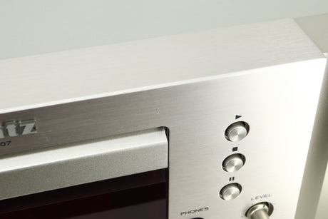 Close up view of a dent on the fascia of a used Marantz CD6007 CD Player in silver finish 