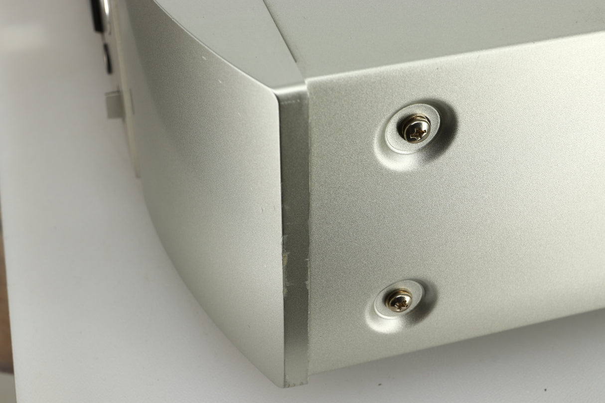 Close up view the side of the fascia of a used Marantz NA6005 Network Player in silver finish showing scratches and marks