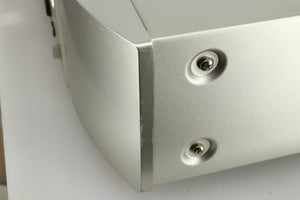 Close up view the side of the fascia of a used Marantz NA6005 Network Player in silver finish showing scratches and marks