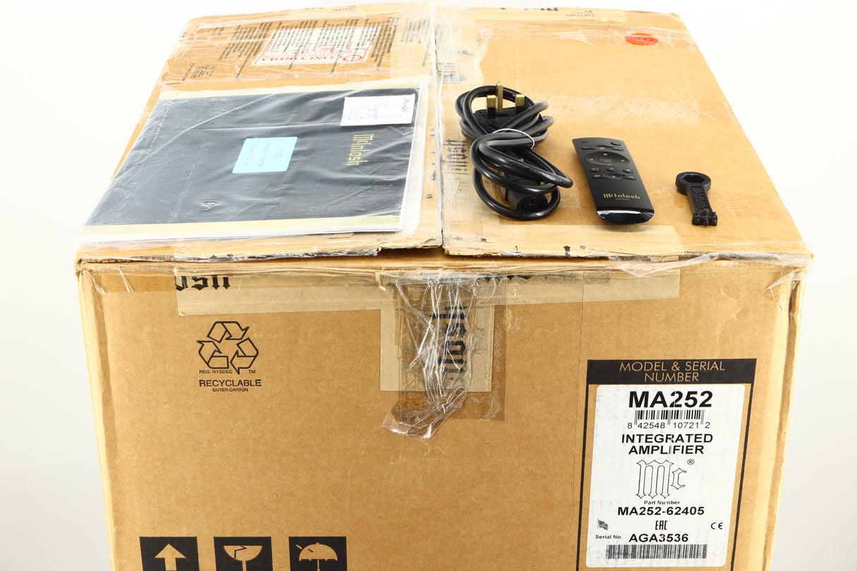 Box of a used McIntosh MA252 Integrated Amplifier showing manual, mains cable, remote, and speaker terminal tool
