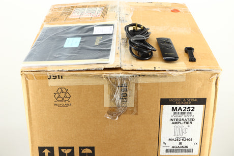Box of a used McIntosh MA252 Integrated Amplifier showing manual, mains cable, remote, and speaker terminal tool