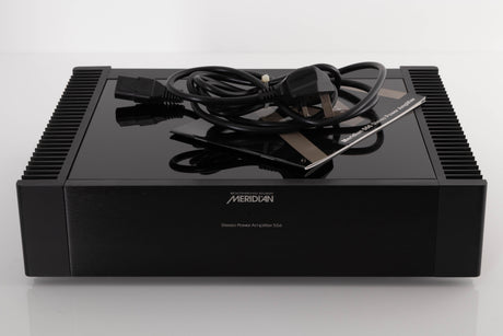 Front view of a used Meridian 556 Stereo Power Amplifier with mains cable, and manual