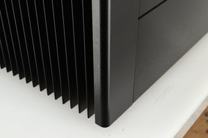 Close up of a used Meridian 557 Power Amplifier in a black finish showing a small scratch on front left corner 