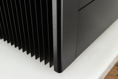 Close up of a used Meridian 557 Power Amplifier in a black finish showing a small scratch on front left corner 