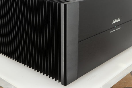 Front left corner of a used Meridian 557 Power Amplifier in a black finish