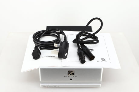 Top view of a used Moon 320S Power Supply in a silver finish showing Mains Cable, DIN Cable and Manuals