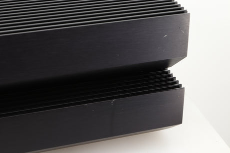 Close up view of a pair of used Musical Fidelity MA50 Class A Monoblock Power Amplifiers in Black finish showing scratches on the right side of the fascia