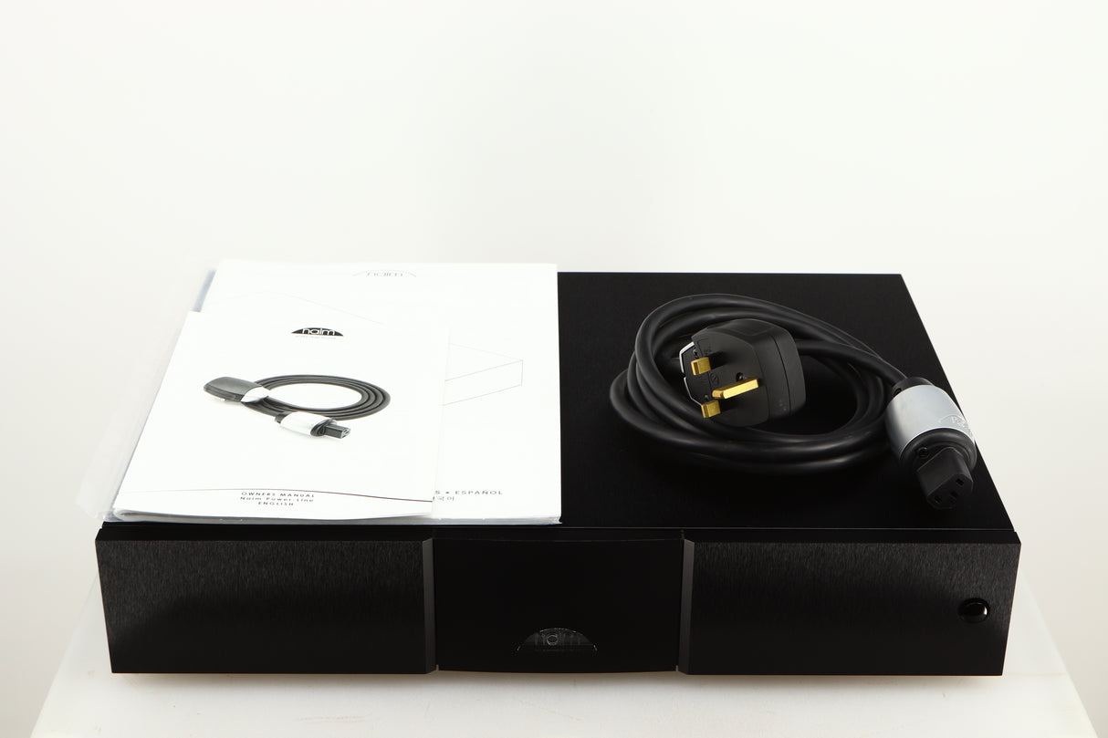 Top of a used Naim CD555PS DR Power Supply in a black finish showing Manual and Power-Line Mains Cable