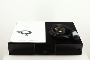 Top of a used Naim CD555PS DR Power Supply in a black finish showing Manual and Power-Line Mains Cable